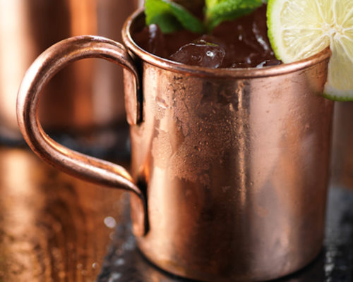 moscow mule cocktail on wooden table close up